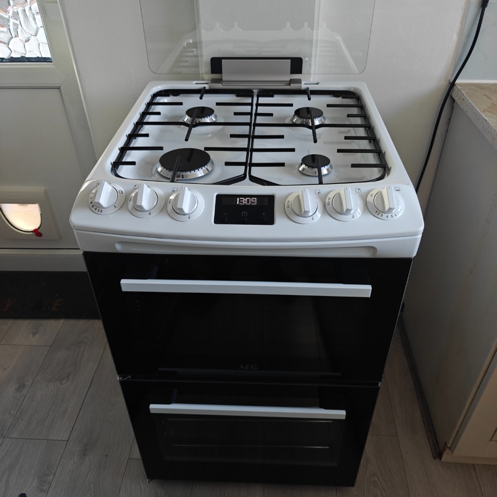 White and black AEG double oven gas cooker with digital display