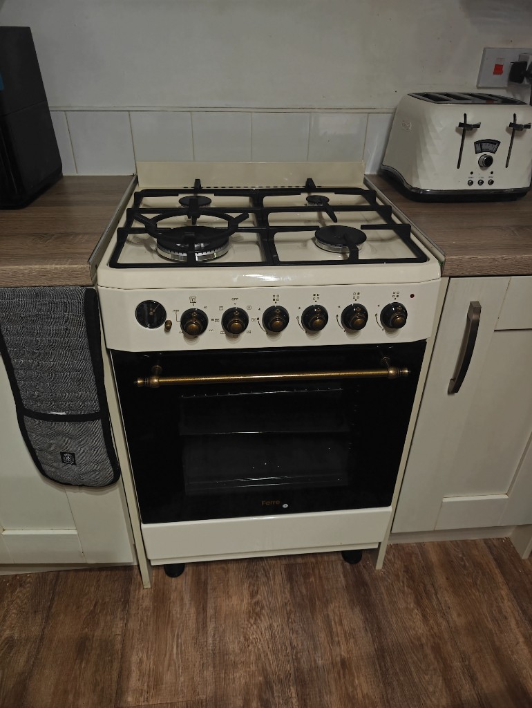 Cream Ferre gas cooker with brass fittings installed in a white kitchen