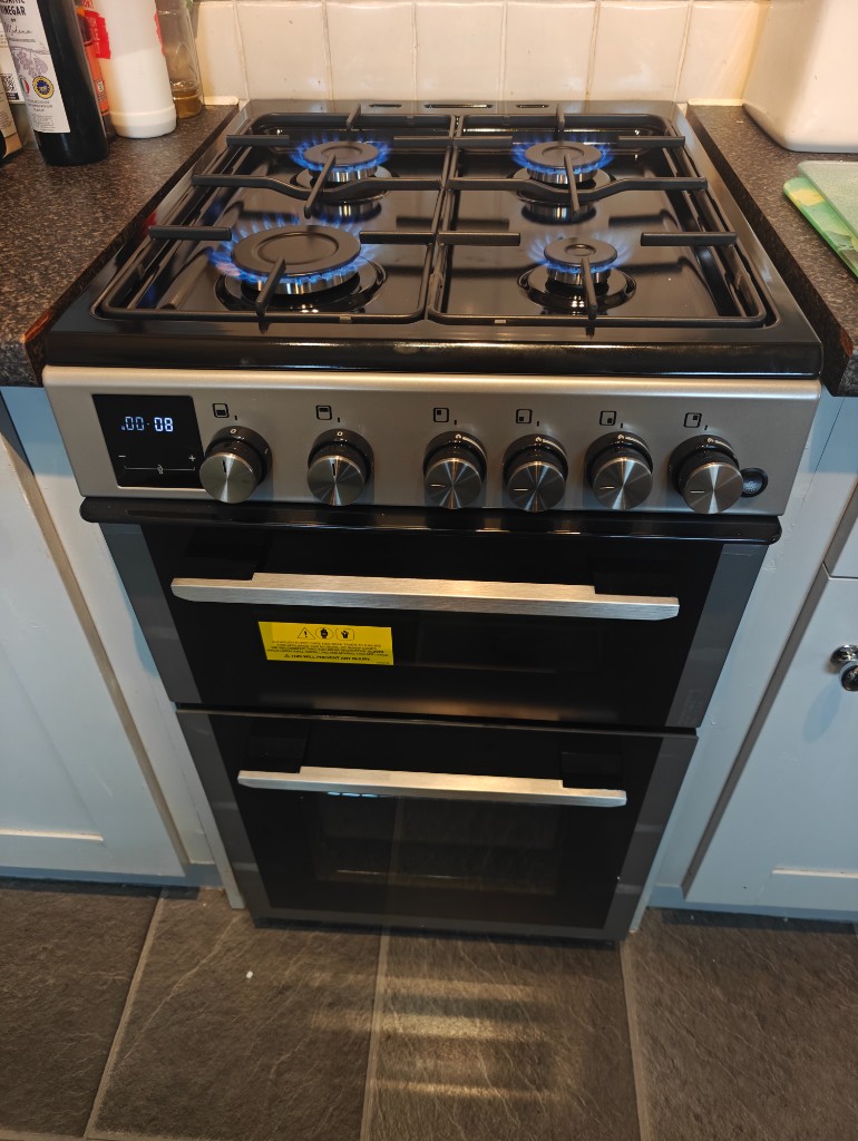 Gas cooker with blue flames lit on all four burners after installation