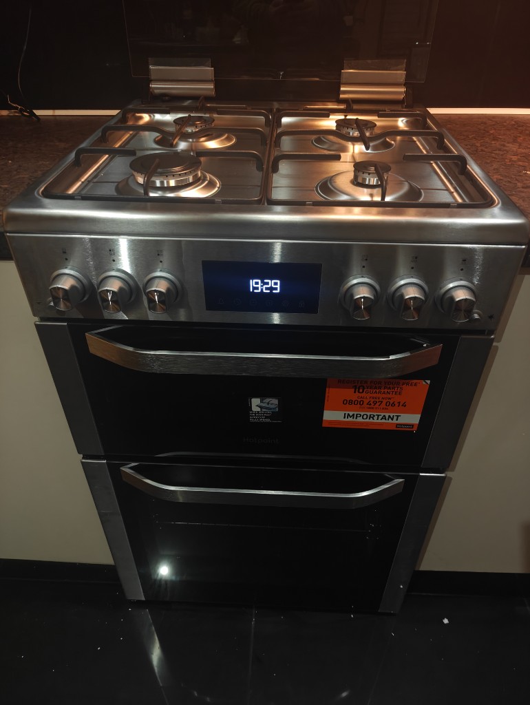 Stainless steel Hotpoint double oven gas cooker with digital clock display